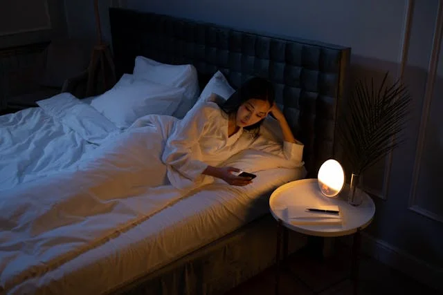 une femme qui consulte son téléphone avant de dormir