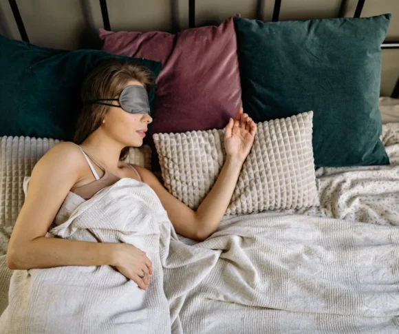 une femme qui dort sur le côté avec un masque